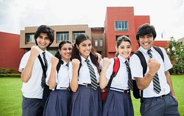 Students in school uniforms celebrating success on campus